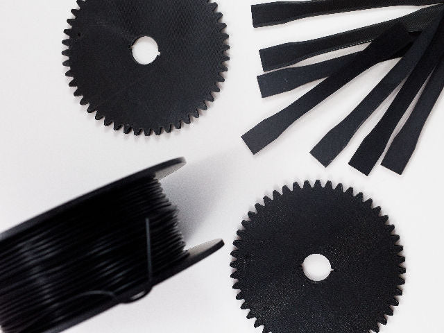 Black gears and test pieces 3D printed with Fluorinar-B™ PVDF filament.