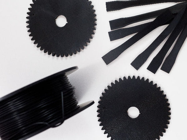 Black gears and test pieces 3D printed with Fluorinar-B™ PVDF filament.