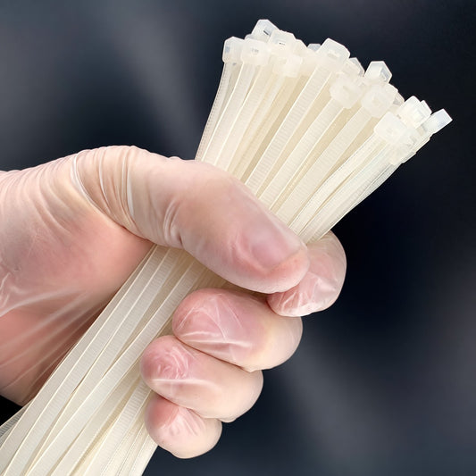 Strong-Ty® natural PVDF cable ties held in a gloved hand.