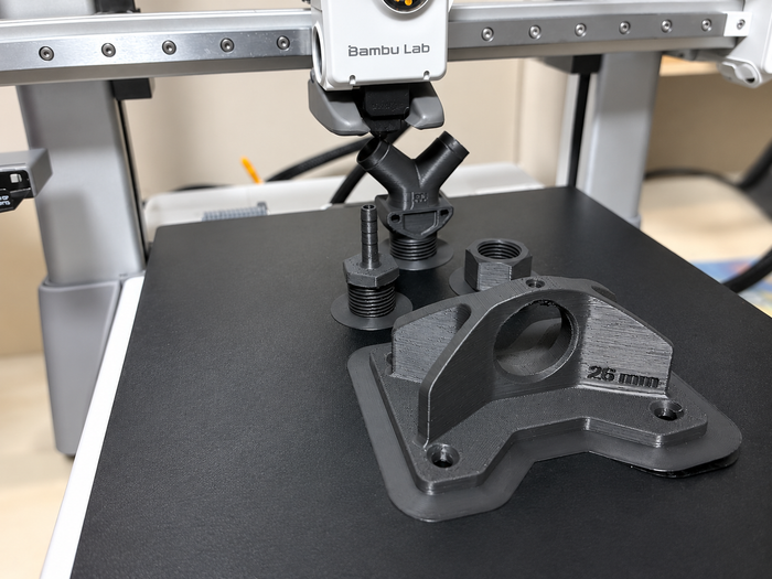 Fluorinar-B™ printed fittings and mounting bracket on a Bambu Lab A1 build plate